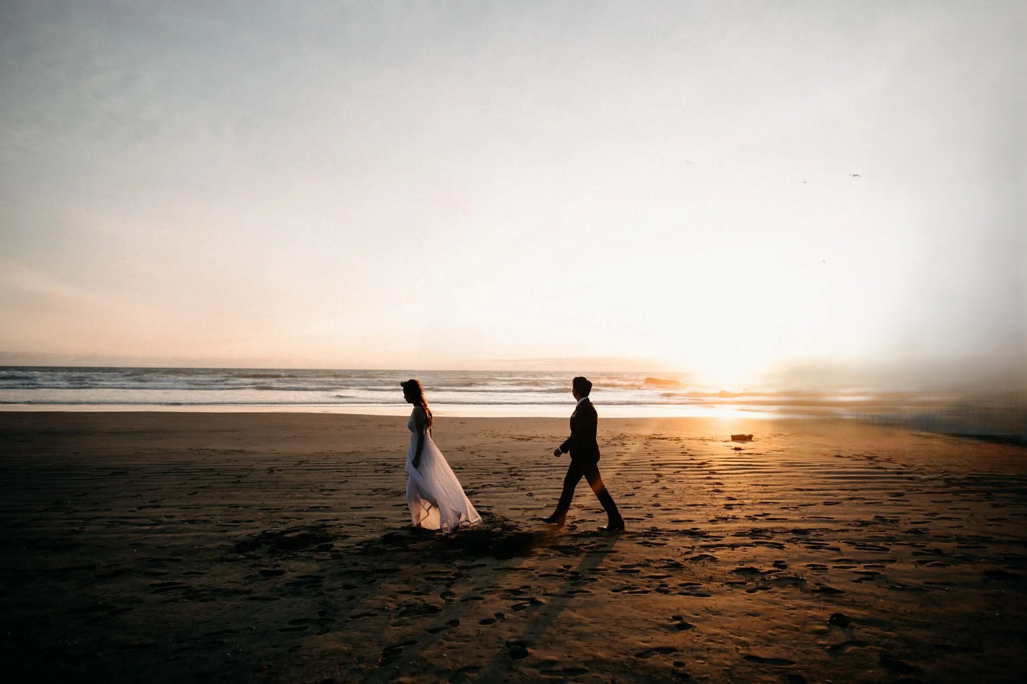 Couple walking along Clearwater Beach during destination wedding