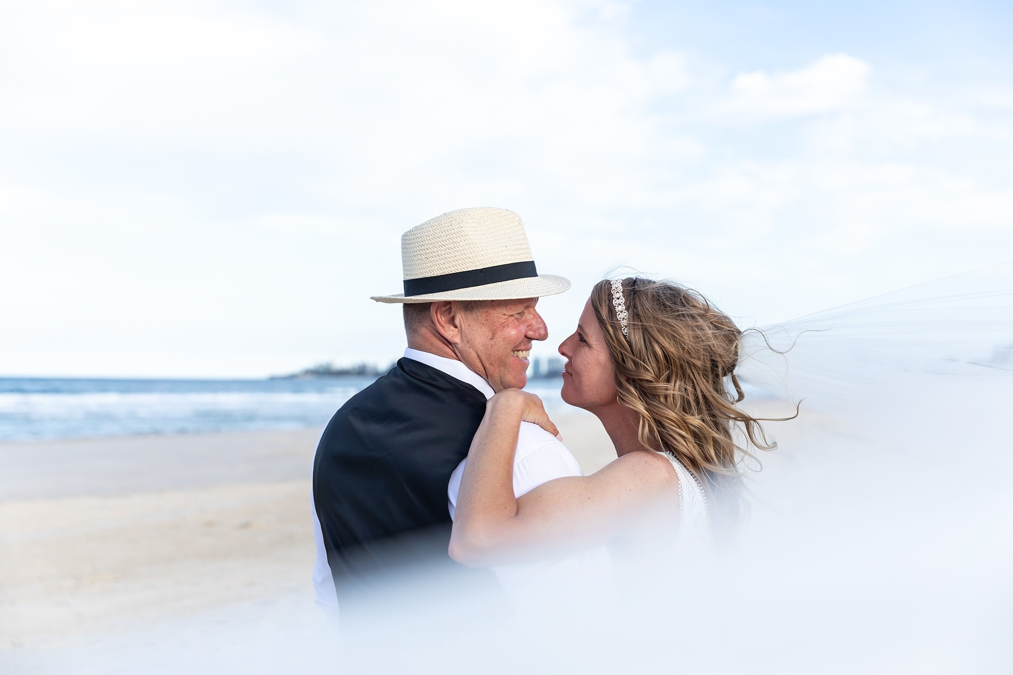 Newlyweds walking along Clearwater Beach at sunset